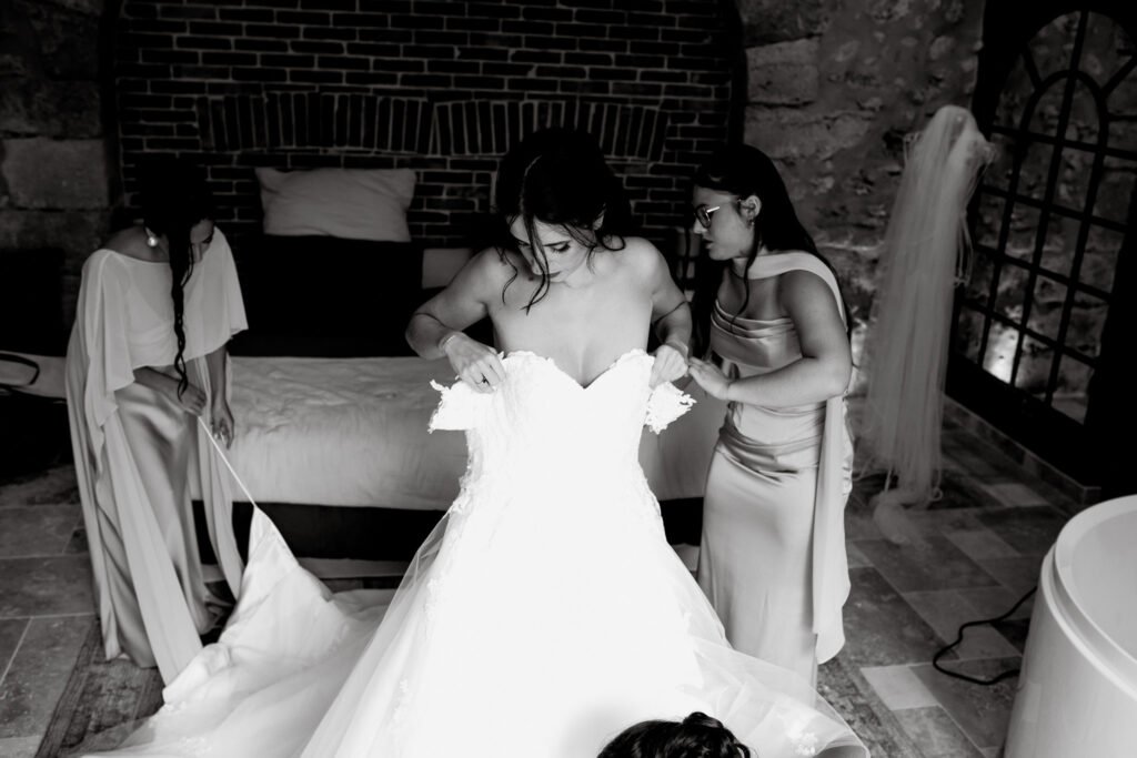 mariée qui enfile sa robe de mariage sur bordeaux